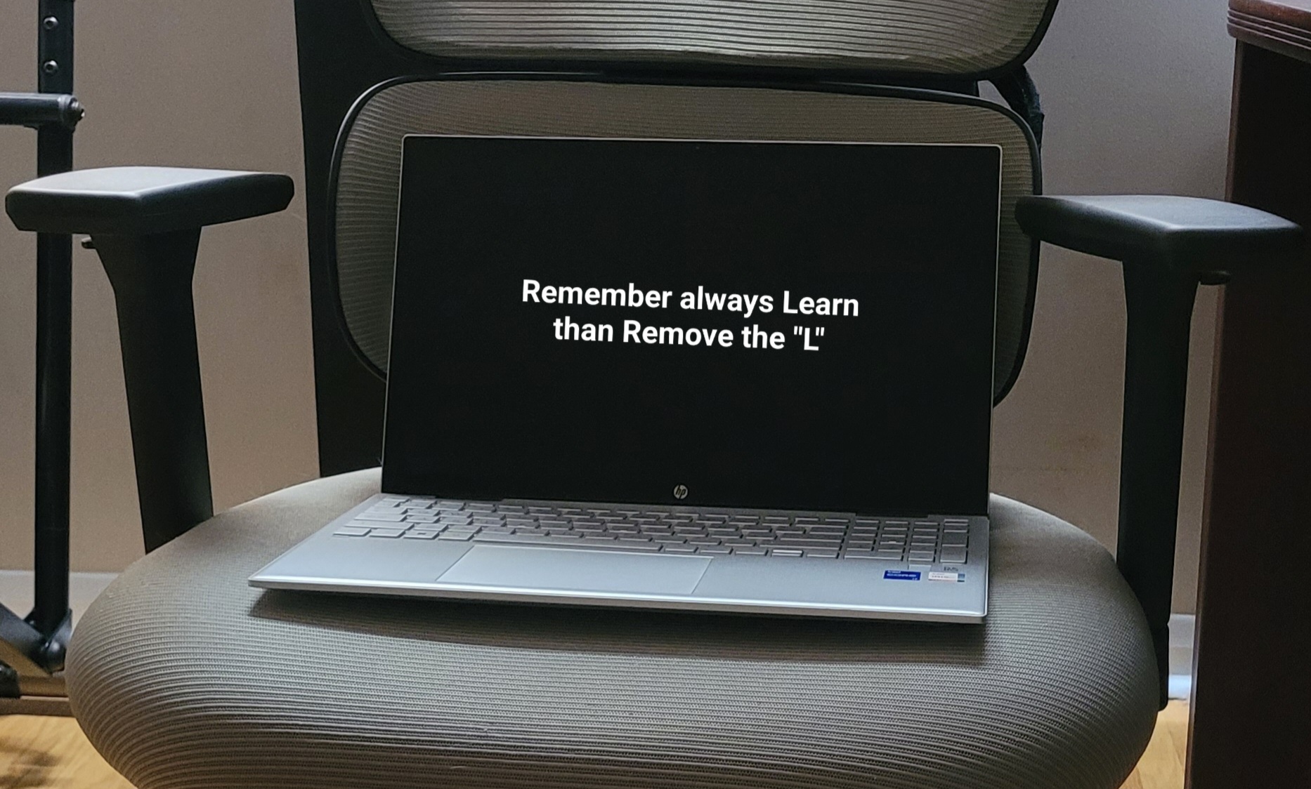 Laptop on a chair displaying the motivational quote: Remember always Learn than Remove the L